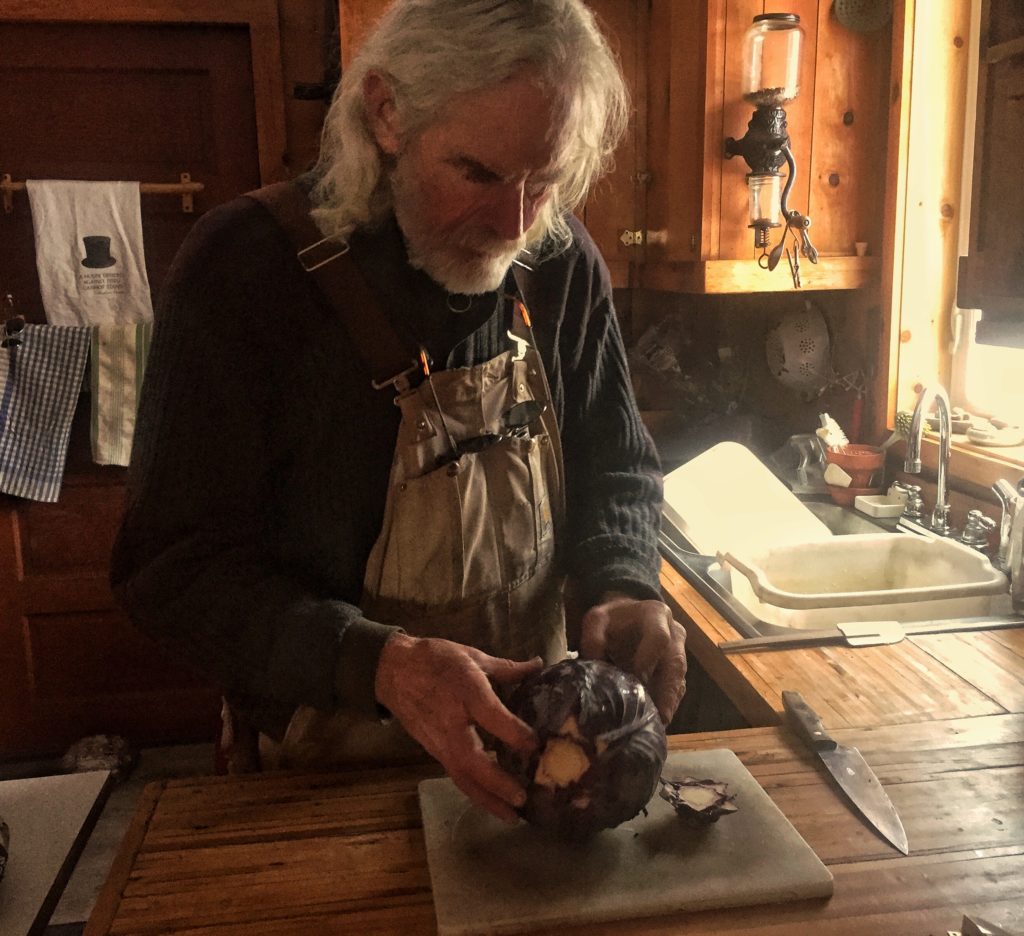 Daddy preparing a purple cabbage he grew. It spent the winter in cold storage, and is now being prepped for salad.